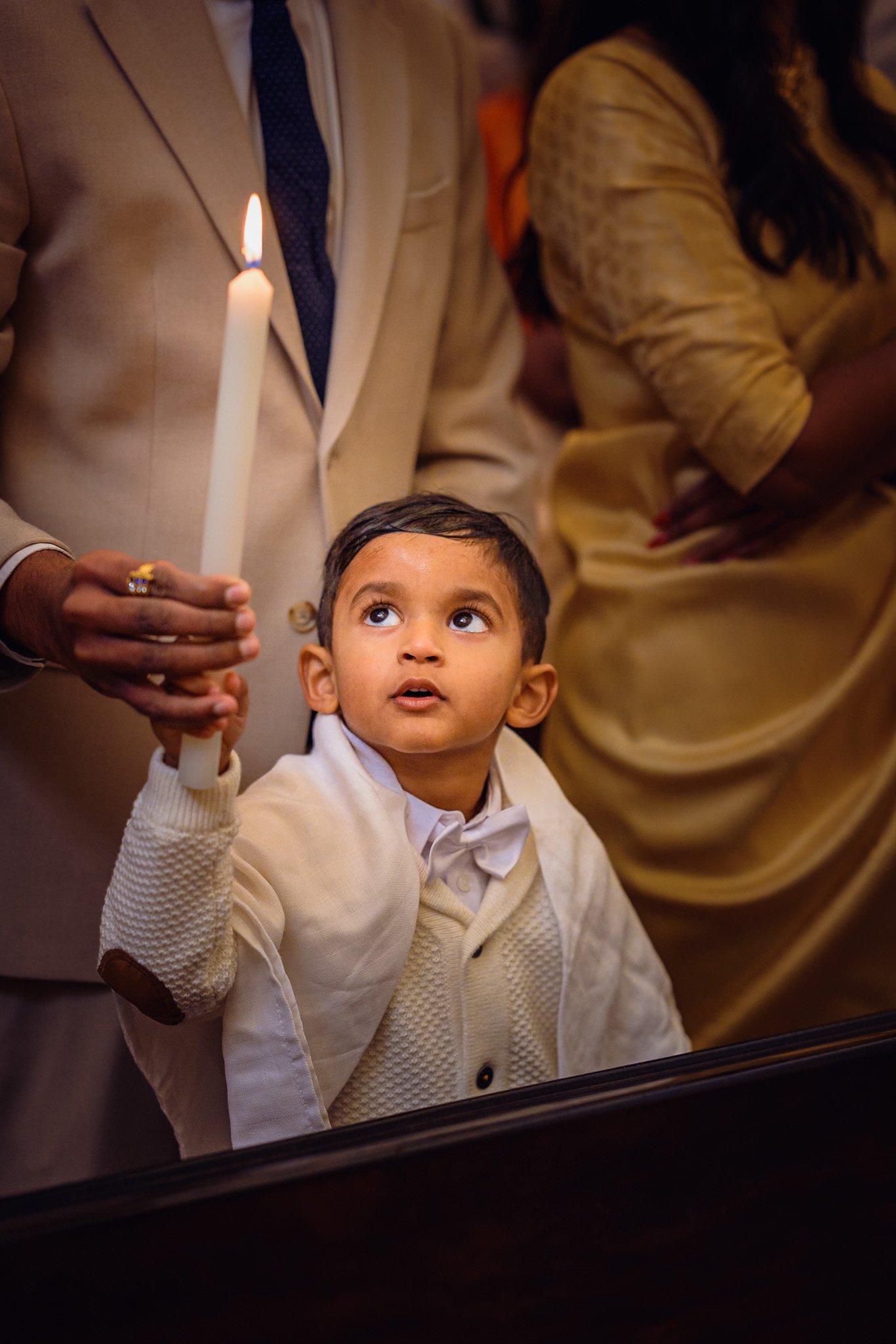 Reverence in a child's eyes holding the baptismal candle